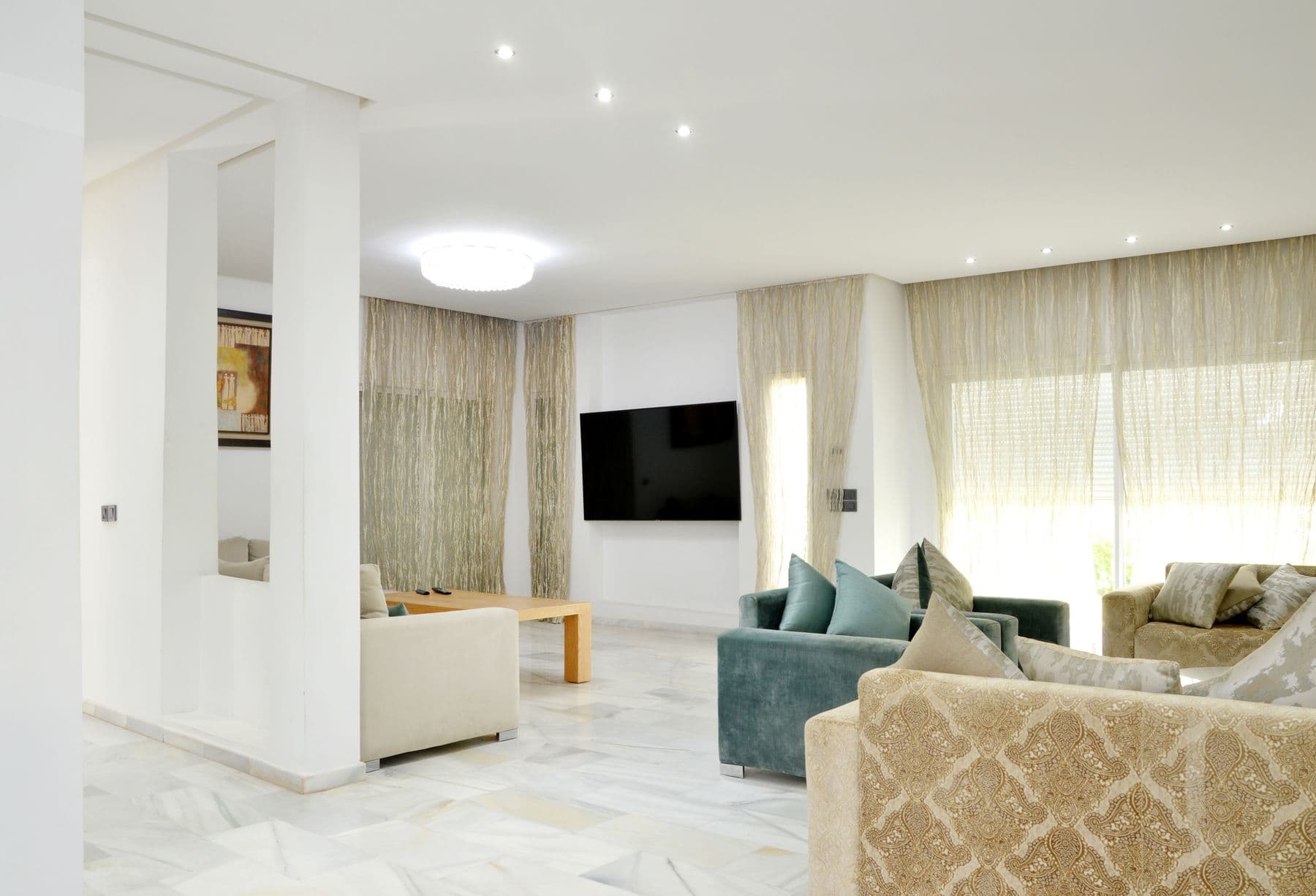 Open-plan sitting room with doors onto the covered terrace facing the marina