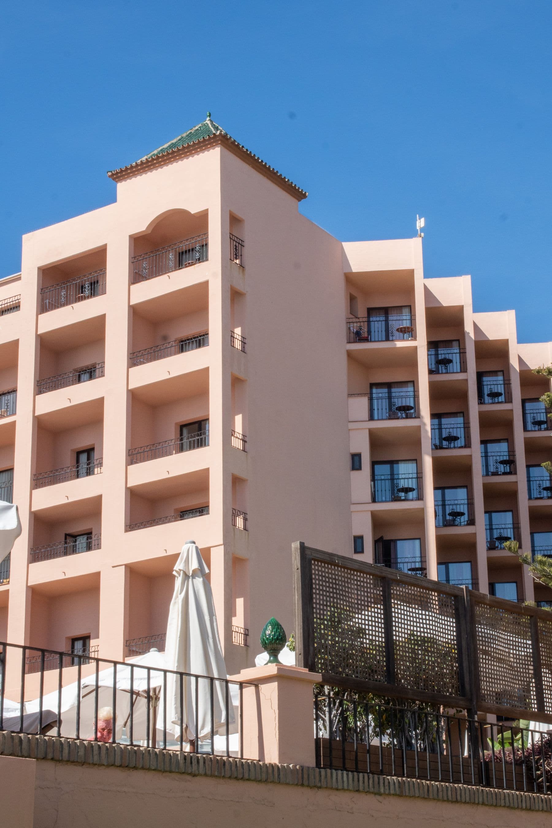 Front-line beach residence in Elviria seen from the promenade, with the communal garden gate in the foreground